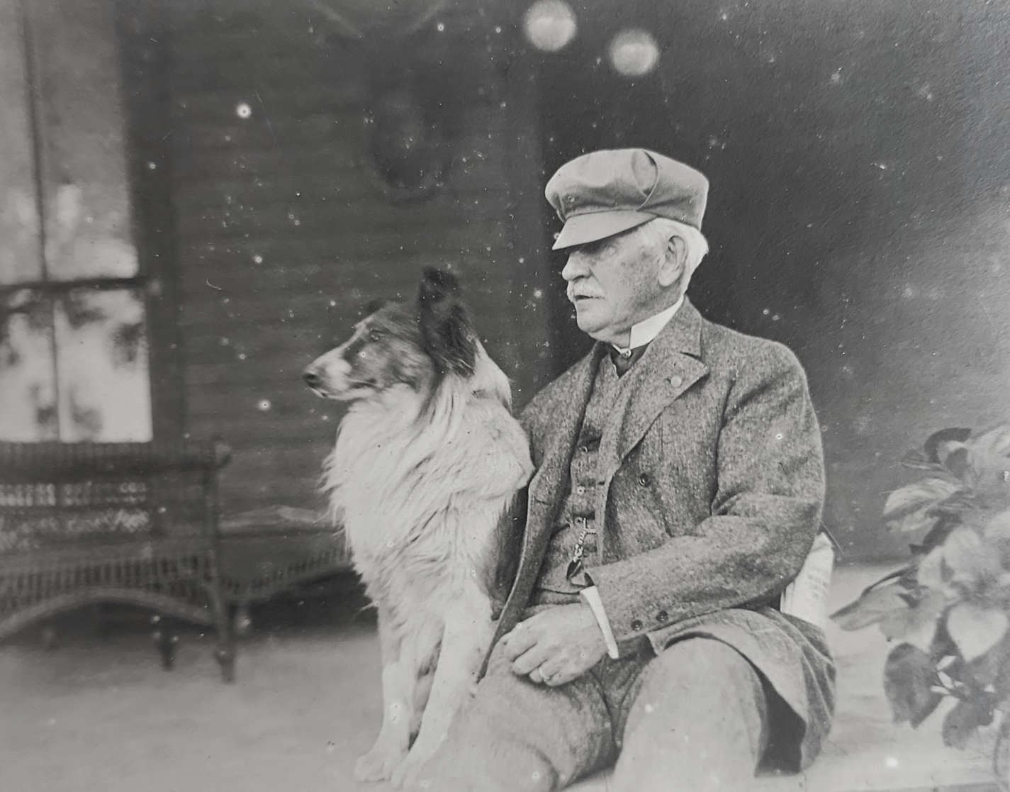 Will J. Davis with collie on porch at Willowdale Farm in Crown Point